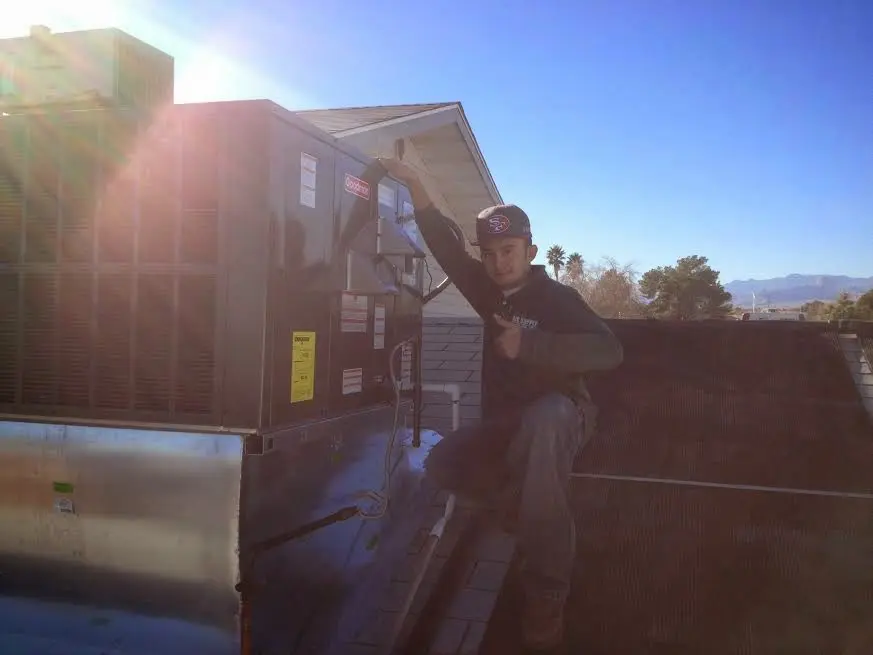 HVAC technician performing Heat Pump Repair on a rooftop unit in Aurora
